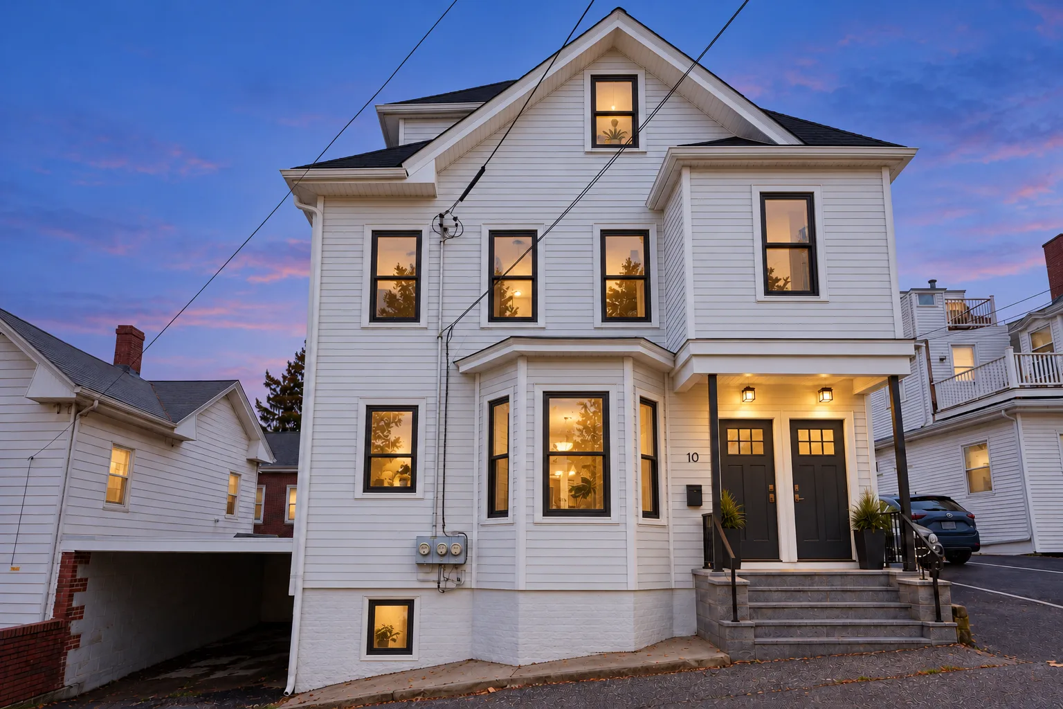 The Scholars House — a white clapboard house at dusk
